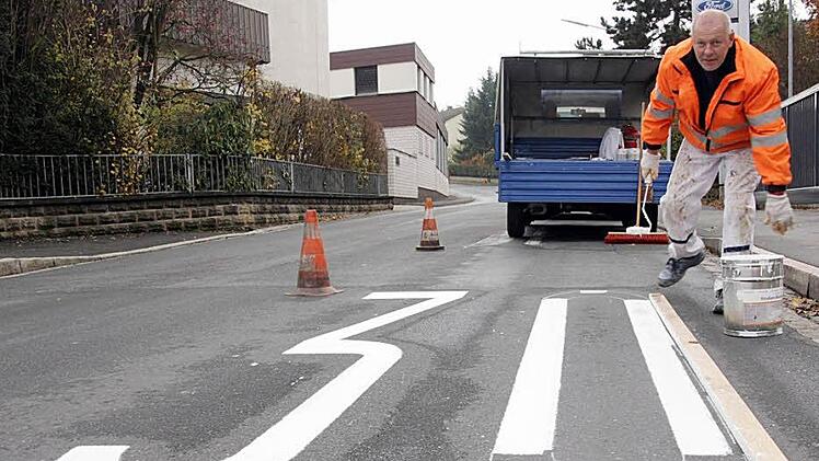 Die Markierungen auf der Straße sollen zusätzlich auf die geltende Tempo-30-Zone hinweisen. Georg Badum hat am Montag damit angefangen, sie auf der Straße (hier Bechhofener Weg) aufzumalen.  Jetzt werden noch die restlichen Markierungen aufgemalt. Fotos: Sebastian Martin