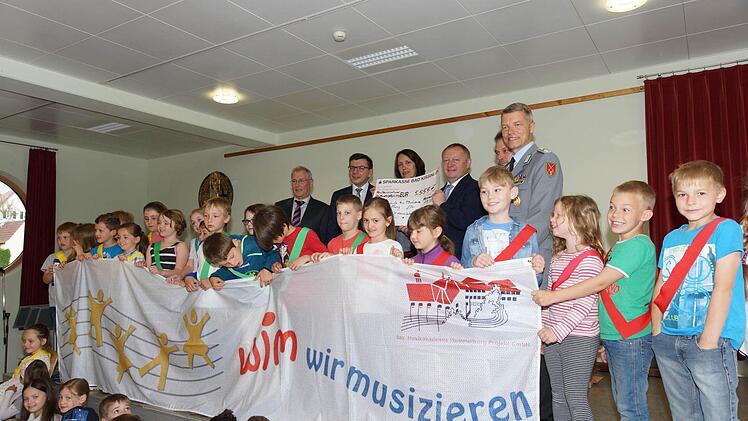 Spendenübergabe: Schulamtsdirektor Josef Hammerl, Bürgermeister Armin Warmuth, Konrektorin Barbara Jenkner, Landrat Thomas Bold, Kuno Holzheimer von der Musikakademie und Oberstleutnant Andreas Eichhorn (hinten von links). Foto: Arkadius Guzy