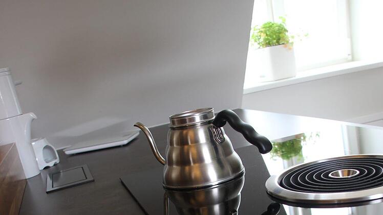 Moderne Küche in altem Haus. Problem: Wo soll die Dunstabzugshaube hin? Sie wurde schließlich mittig in die Kochstelle integriert, Dampf und Rauch werden nach unten abgesaugt.