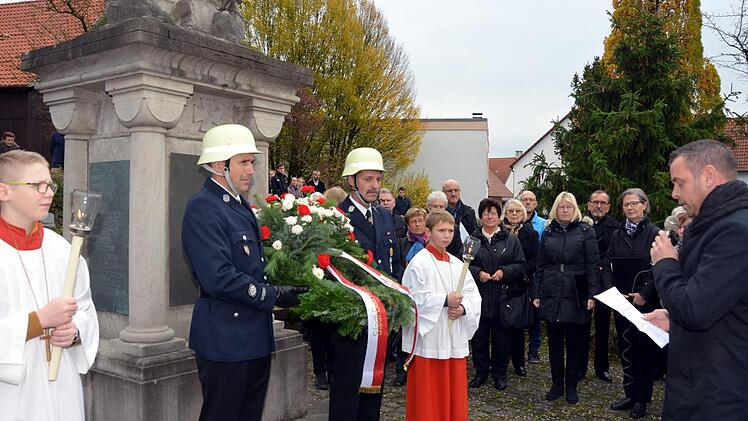 Im Beisein der Freiwilligen Feuerwehr und einem guten halben Dutzend Fahnenabordnungen der Ortsvereine legte Bürgermeister Toni Schick am Kriegerdenkmal in Reiterswiesen einen Kranz nieder. Foto: Peter Rauch