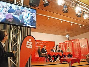 Andrang im Sozialkaufhaus als Einspieler zu Beginn des Regionentalks. Auf dem Podium (von links) Barbara Kammerscheid, Detlef Juranek, Moderator Thomas Apfel, Michael Busch und Jürgen W. Heike. Foto: nel