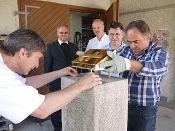 Steinmetz Herbert Sailer (links) und Goldschmied Alois Plätzer fügen Reliquienschrein und Steinstele zusammen.  Foto: Pauline Lindner