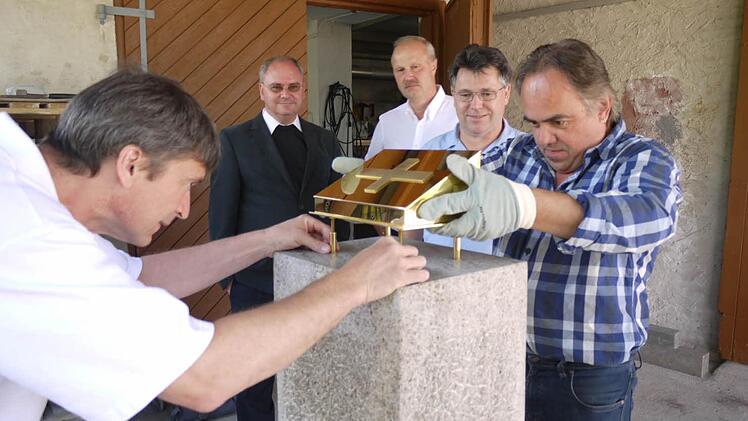 Steinmetz Herbert Sailer (links) und Goldschmied Alois Plätzer fügen Reliquienschrein und Steinstele zusammen.  Foto: Pauline Lindner
