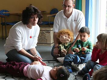 Elvira Schmidt und Daniel Lorz beim Trau-Dich-Kurs im Rut-Stocke-Kindergarten in Einberg: Interessiert hören die Kinder den beiden Rot-Kreuz-Mitarbeitern zu, wie sie erklären, was Erste Hilfe bedeutet.Fotos: Christiane Lehmann