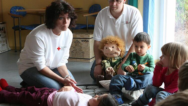 Elvira Schmidt und Daniel Lorz beim Trau-Dich-Kurs im Rut-Stocke-Kindergarten in Einberg: Interessiert hören die Kinder den beiden Rot-Kreuz-Mitarbeitern zu, wie sie erklären, was Erste Hilfe bedeutet.Fotos: Christiane Lehmann