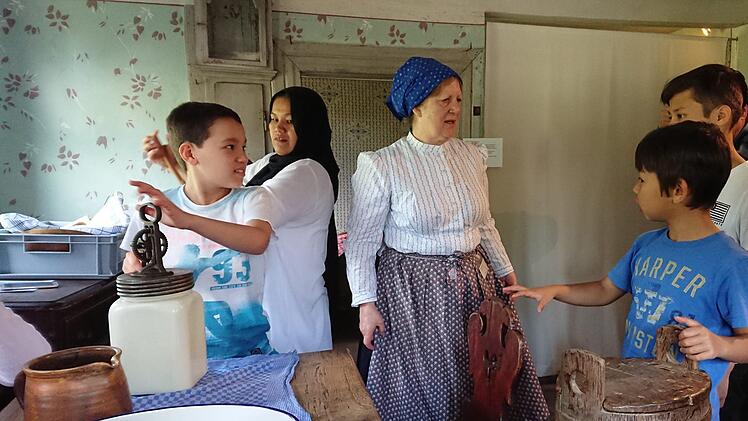 Die Kinder versuchen sich am Butter machen.Foto: Michael V&ouml;lkel