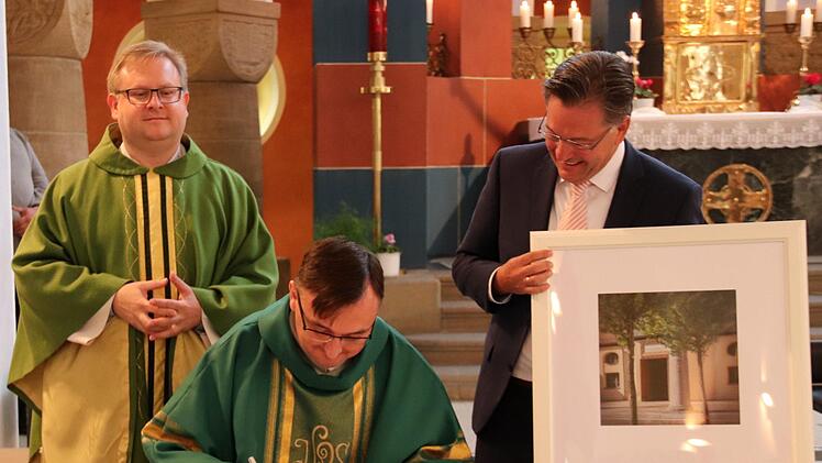 Beim Eintrag ins Goldene Buch, von links: Pfarrer Thomas Ringer, Pfarrer Jaroslaw und Bürgermeister Karsten Fischkal Foto: Johanna Blum