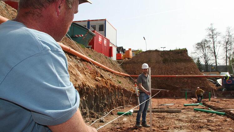 Erich Stockmann und Alexander Weber messen die Gebäude-Achse der Tiefgarage ein. Fotos: Ulrike Müller