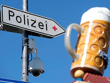Eine Videokamera und ein Hinweisschild auf die Polizei h&auml;ngen in M&uuml;nchen dem Oktoberfestgel&auml;nde an einer Stra&szlig;enlaterne. Da sich auch auf dem weltgr&ouml;&szlig;ten Volksfest immer wieder sexuelle &Uuml;bergriffe ereignen, hat die Polizei die Sicherheitsvorkehrungen verst&auml;rkt. Foto: Sven Hoppe, dpa