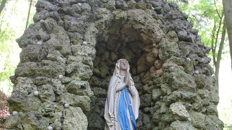 An der Maria-hilf-Grotte zünden die Frauen ein Licht an. Fuchs