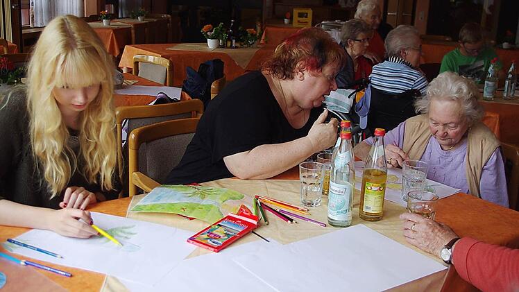 Jessica Rudolph und Arnhild Schlingschröder malen mit Elfriede Müller. Foto: Heike Schülein