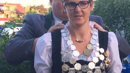 Schießleiter Bastian Angermüller übergibt Schützenkönigin Ilona Bauer die Königskette.