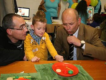 IHK-Präsident Heribert Trunk experimentiert mit Torsten und Hendrik Klier.