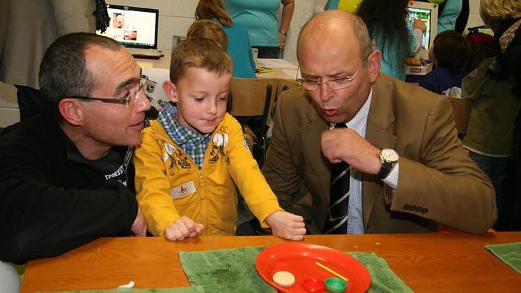 IHK-Präsident Heribert Trunk experimentiert mit Torsten und Hendrik Klier.