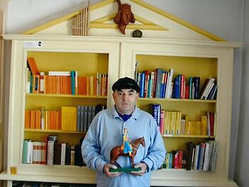 "Haus der Sprachen" nennt Erwin Sternadl den Bücherschrank, in dem er Wörterbücher aus aller Welt sammelt. In den Händen hält der Bamberger sein "Erkennungszeichen" , den Bamberger Reiter.  Foto: Repro/FT
