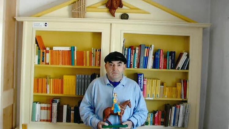 "Haus der Sprachen" nennt Erwin Sternadl den Bücherschrank, in dem er Wörterbücher aus aller Welt sammelt. In den Händen hält der Bamberger sein "Erkennungszeichen" , den Bamberger Reiter.  Foto: Repro/FT