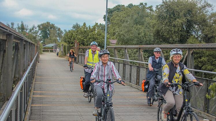 Karl-Heinz Heinrich (hinten rechts) und seine Wegbegleiter überqueren die Regnitz per E-Bike.
