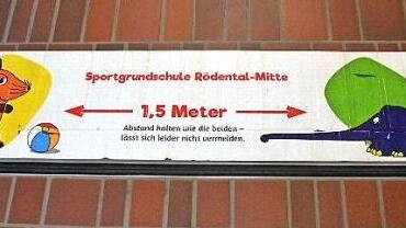 Schilder auf dem Boden erinnern die Kinder immer daran, dass sie den geforderten Abstand einhalten sollen.