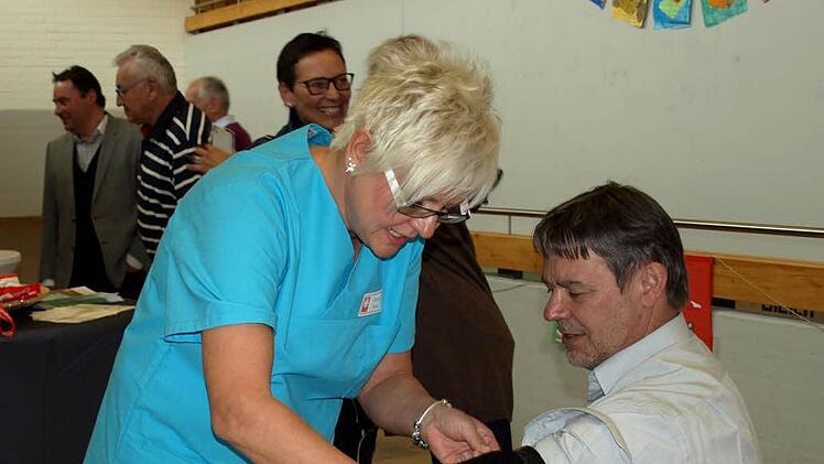 Bürgermeister Gerhard Wunder lässt sich von Caritas-Mitarbeiterin Barbara Müller den Blutdruck messen.
