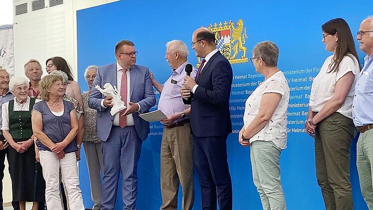 Im Heimatministerium in Nürnberg überreichte Heimat- und Finanzminister Albert Füracker den Heimatpreis Nordbayern an die Dorfgemeinschaft Wermerichshausen und Münnerstadts stellvertretenden Bürgermeister Andreas Trägner.