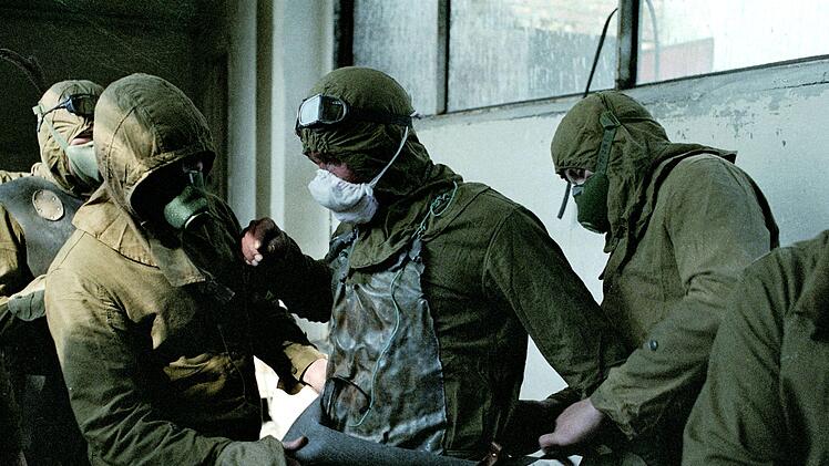 Tausende Helfer, die das Dach des verschmutzten Reaktors 3 reinigen sollen, legen Schutzkleidung an.