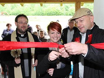 Unter den Augen von Pfarrer Daniel Schuster (l.) und Bürgermeister Claus Schwarzmann schneidet Julia Fronhöfer (m.) bei der Eröffnung des Drügendorfer Jugendtreffs das Band an der Eingangstür durch. Fotos: Erlwein