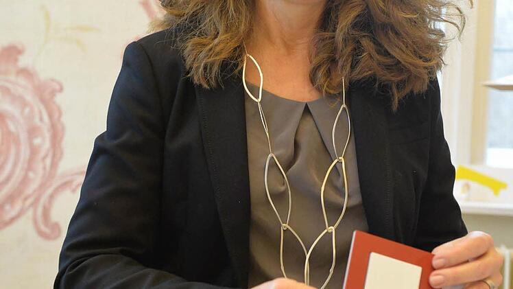 Birgit Dietz zeigt einen farbig eingerahmten Lichtschalter.Foto: Ronald Rinklef