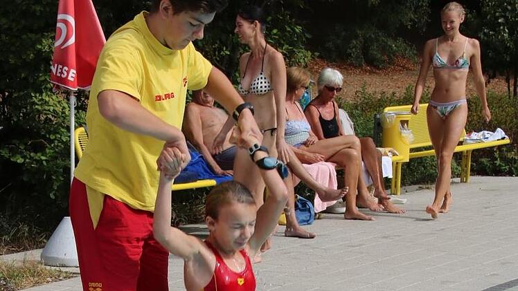 Jannis Trinkwalter und Denise Will zeigen hier, wie ein Retter vom Beckenrand aus einem in Not geratenen Schwimmer aus dem Wasser helfen kann.Matthias Einwag