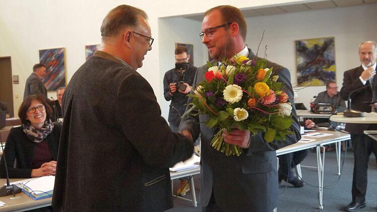 Jetzt geht's los: Stichwahl-Kontrahent  Martin Stingl (links)  ist einer der ersten Gratulanten für Sebastian Straubel nach der Vereidigung. Christine Heider (links, in Hintergrund) und  Jürgen W.  Heike (rechts)  verfolgen  sichtlich  erfreut die Vereidigung des ersten CSU-Landrats nach Ende des  Zweites Weltkriegs. - Foto: Berthold Köhler