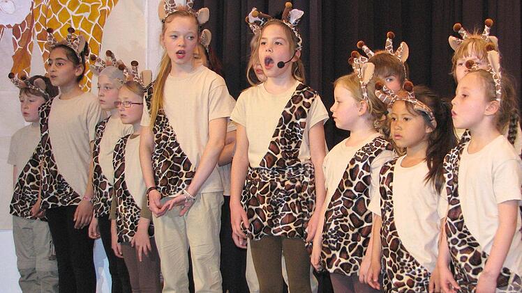 Die Giraffenherde sang laut und überzeugt: "Wir sind die einzigen Helden der Welt" (von links: Nick Naumann, Nalin Özdemir, Sophie Albakowa, Annalena Schneider, Annabell Schneider, Elena Barth, Lily-Esther Bartl, Melissa Popp, Lilou Schneiderbanger sowie verdeckt Darleen Holldorf, Benjamin Schramm und Elias Bartl).