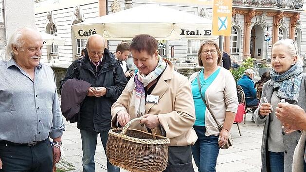 Hedda Hanft (mit Korb) verteilt kleine Fl&auml;schchen des Hoflik&ouml;rs an die Teilnehmer der Premierenf&uuml;hrung "Coburg kulinarisch". Bratwurst, Schm&auml;tzchen und Lik&ouml;r sind im F&uuml;hrungspreis mit drin.