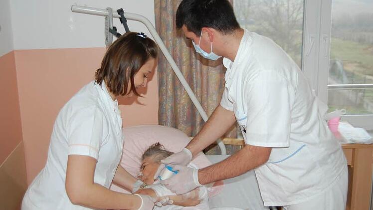 Krankenpfleger Matej Mlinaric (rechts) und Pflegehelferin Ivana Havoic legen einen Verband an.