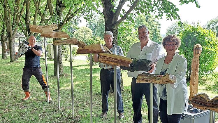 Mit der Kettensäge hat Sebastian Waßmann (links) sein Kunstwerk runderneuert. Mit im Bild (nach rechts) Erwin Tischer, Bürgermeister Gerhard Schneider und Inge Tischer.