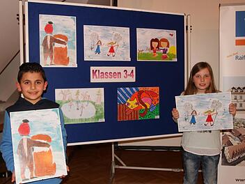 Die beiden stolzen Preisträger Wesam Alsouki (links) und Selina Göke (rechts) vor den Siegerbildern aus den Klassen 3 und 4 Foto: Günther Geiling