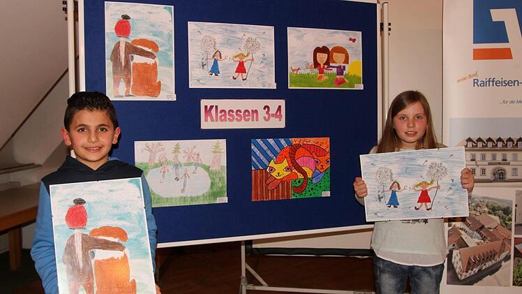 Die beiden stolzen Preisträger Wesam Alsouki (links) und Selina Göke (rechts) vor den Siegerbildern aus den Klassen 3 und 4 Foto: Günther Geiling