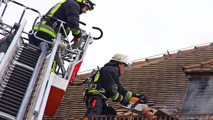 Mit Drehleiter und Kettensäge bahnten sich die Feuerwehrleute einen Weg zum Brandherd unter dem Dach. Fotos: Marco Meißner