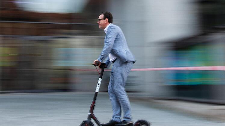 Der Pressesprecher der Stadtwerke Bamberg, Jan Giersberg, fährt mit einem Elektro-Scooter des US-amerikanischen E-Scooter-Sharing Anbieters "Bird". Nicolas Armer/dpa