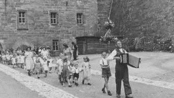 Als Kind hat der heute 68 Jahre alte Hans-Joachim Kunze auf der Plassenburg gelebt. Aus seinen Erinnerungen berichtet er am Donnerstag in einem Vortrag. Auf dem Bild von einem internen Fest des damaligen Plassenburg-Kindergartens (vermutlich 1951/52) ist er zu sehen - und zwar ist er der Knirps vorne, der von den beiden Mädchen an der Hand genommen wird. Die zweite Person hinter ihm ist sein Bruder Frank, seine Schwester Marianne Diroll läuft links neben seinem Bruder. Foto: Stadtarchiv