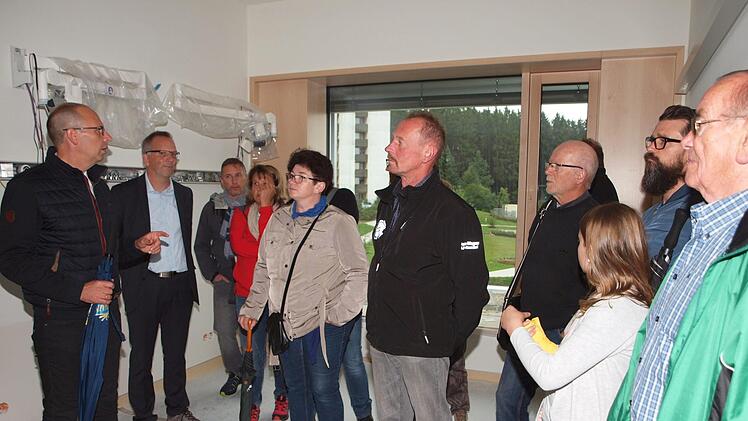 Landrat Christian Meißner demonstriert hier einigen Teilnehmern des Bürgerforums eines der bereits teilweise eingerichteten Patientenzimmer. Foto: Alfred Thieret