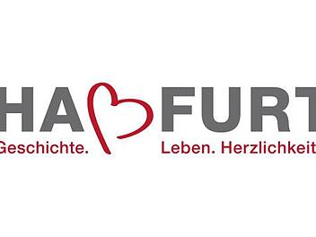 So sieht das neue Logo der Stadt Haßfurt aus: ein grauer Schriftzug mit einem leicht gedrehten roten Herzen anstelle des "ß" und darunter der Claim "Geschichte.Leben.Herzlichkeit."