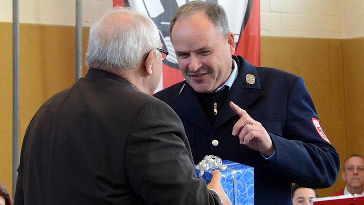 Bürgermeister Siegfried Erhard überreicht Bühner ein Geschenk.