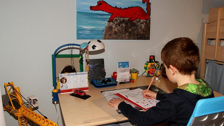 Nicolas aus der zweiten Jahrgangsstufe der Grundschule Kirchlauter  bei der Bearbeitung seiner Arbeitsblätter daheim am eigenen SchreibtischGünther Geiling
