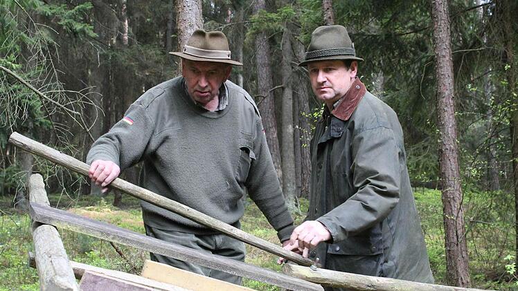 Franz Schmidtlein (links) und Fritz Stehl überprüfen, was sie von dem zerstörten Hochsitz noch verwenden können. Fotos: Thomas Heuchling