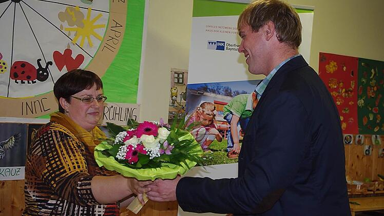 Der Geschäftsführer der katholischen Kindertagesstätten im Dekanat Kronach, Thomas Pyka (rechts), überreichte Andrea Engelhardt die Ehren-Urkunde des Freistaates Bayern sowie einen Blumenstrauß.