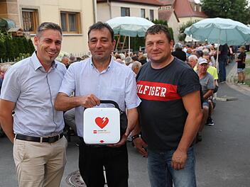 Die beiden Vorsitzenden der Dorfgemeinschaft, Georg Kratz und sein Stellvertreter Daniel Fleischmann, und Bürgermeister Torsten Gunselmann (l.) bei der Übergabe des Defibrillators Foto: Mathias Erlwein
