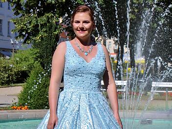 Quellenkönigin Ann-Sophie Brath trägt ein weit schwingendes, wasserblaues Kleid.