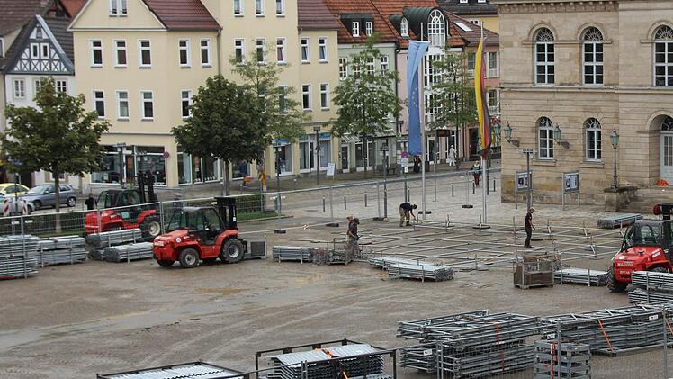 Aus Stapeln von Teilen müssen die Arbeiter die Bühne zusammensetzen, die direkt vor dem Landestheater stehen soll. Fotos: Daniela Pontelicek