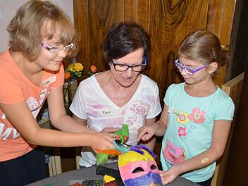 Kreative Frauen unter sich: Luisa und Karin Grom helfen Lucie dabei, ihre Maske zu gestalten. Diese soll eine ganz besonders Lustige werden und künftig Lucies Zimmer schmücken. Foto: Kathrin Kupka-Hahn
