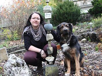 Mischlingsrüde Jasper hat kein Problem damit, dass Frauchen Stefanie Trum Tierbestatterin ist. Vor fünf Jahren hat die 29-Jährige sich im Haßfurter Stadtteil Wülflingen mit ihrem Bestattungsinstitut "Chronos" selbstständig gemacht. Mit im Bild ist ein Muster-Grabstein. Fotos: kk