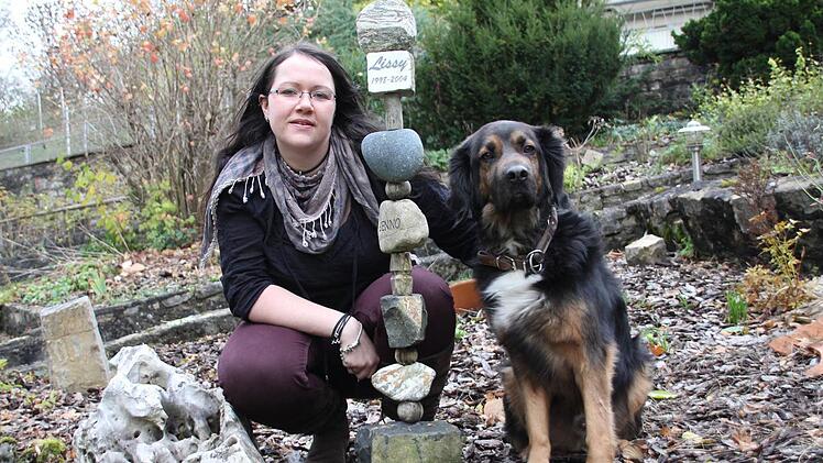 Mischlingsrüde Jasper hat kein Problem damit, dass Frauchen Stefanie Trum Tierbestatterin ist. Vor fünf Jahren hat die 29-Jährige sich im Haßfurter Stadtteil Wülflingen mit ihrem Bestattungsinstitut "Chronos" selbstständig gemacht. Mit im Bild ist ein Muster-Grabstein. Fotos: kk